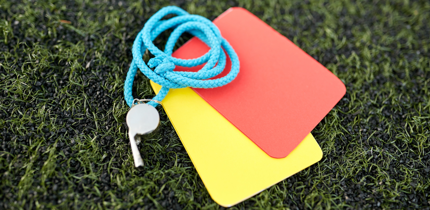 whistle and caution cards on football field